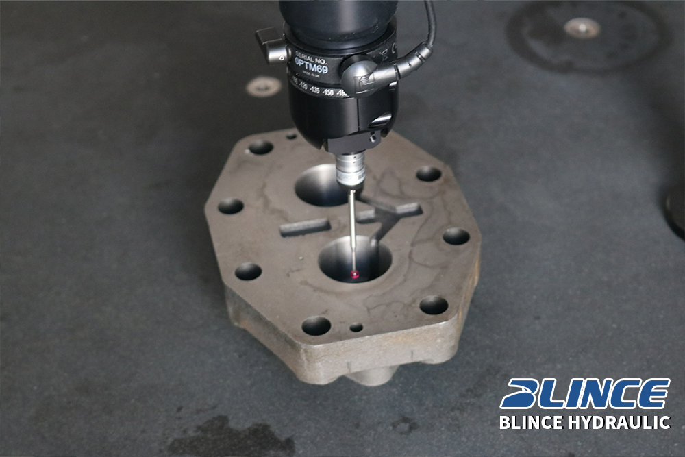 Hydraulic pump housing undergoing precision dimensional inspection before assembly in a production workshop.